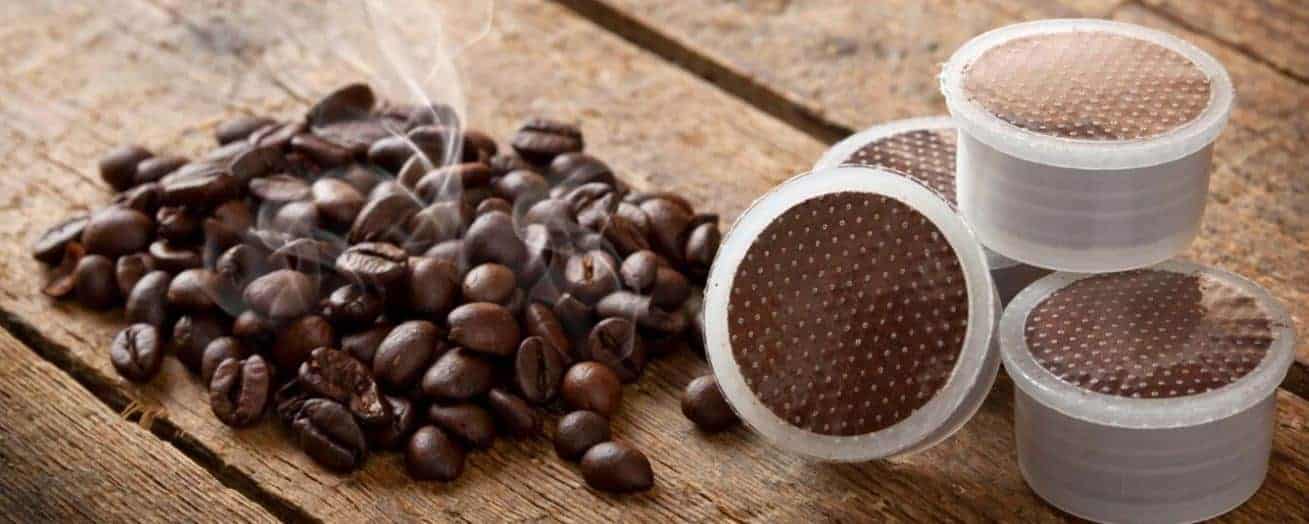 Immagine di caffè sul tavolo caffè con accanto delle capsule di tipo FAP funzionale ad identificare prodotto Caffè Grani Capsule e cialde